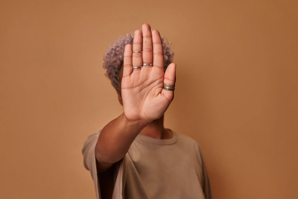 woman showing stop sign with palms on beige background