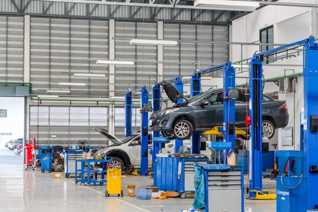 Car in the lifting equipment in the garage being repaired and fixed Car in lifting equipment in garage being repaired and fixed representing motor sector