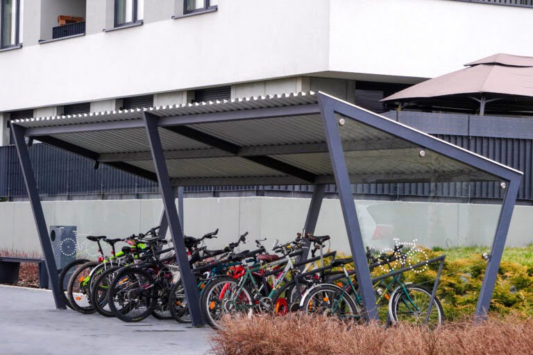 Modern Parking lot with a Bicycle roof near an apartment building with large number of bicycles. Eco-friendly and sports transport in the city.