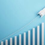 There’s No Energy Price Cap for Businesses – But There Is a Solution 7 Startup and new project concept with white rocket flying up with dotted trajectory above light growth graph on blue background. showing the rise in energy despite the energy price cap