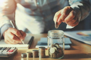 businessman saving money concept. hand holding coins putting in businessman saving money concept. hand holding coins putting in