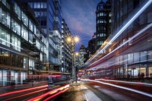 Evening view of a busy road in the City of London with traffic light trails and illuminated skyscrapers in the background, England Bustling streets of Central London representing Electric Vehicles
