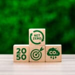 Net Zero By 2050: Can The UK Reach 100% Clean Energy? 3 UK clean energy by 2050 wooden blocks against a wall of bushes
