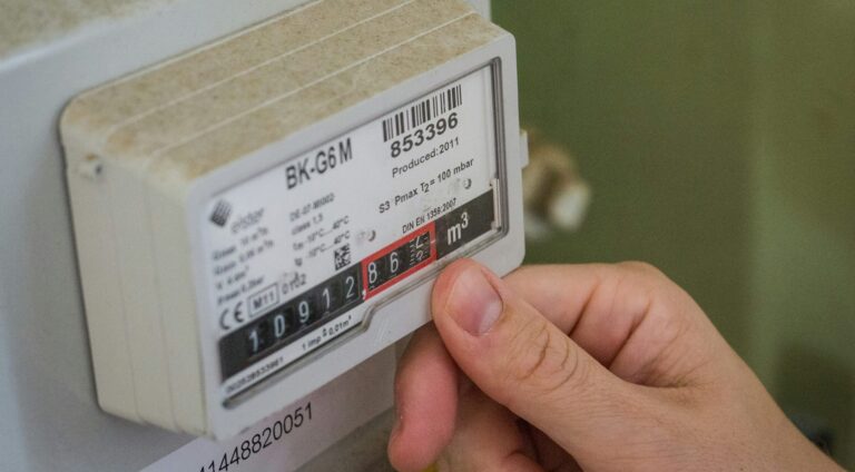 A close-up of a hand and an energy meter representing how we helped a customer get their new energy contract on track