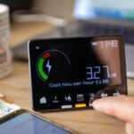 Tomato Energy Has Gone Into Administration — Here’s What You Need to Know 1 A person checking and calculating home energy cost with smart meter representing tomato energy administration.