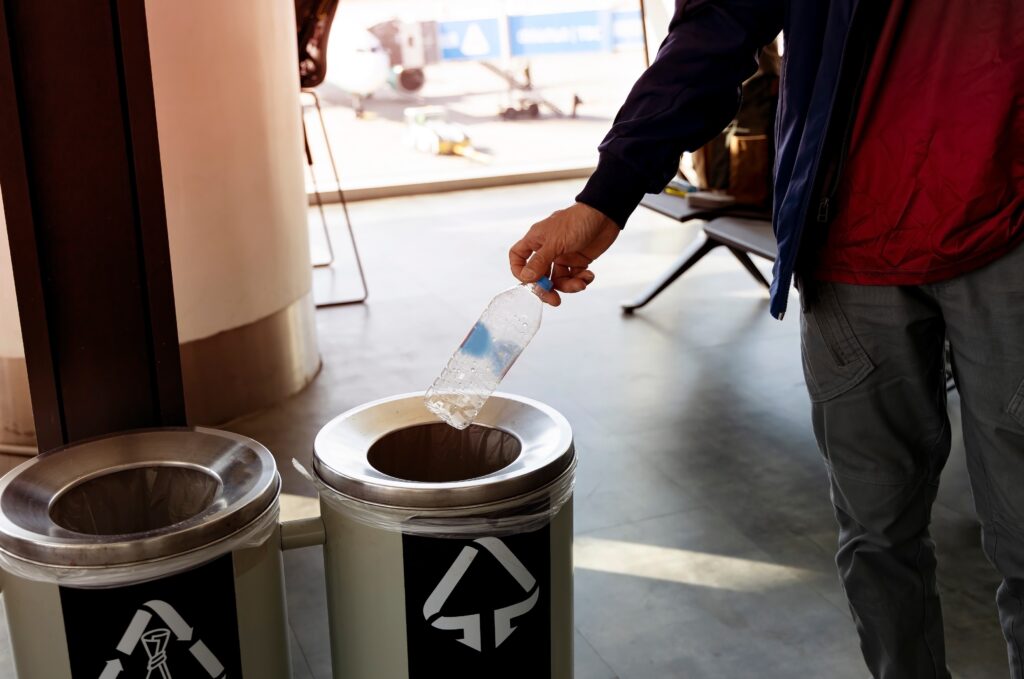 man throwing away a plastic bottle representing business waste