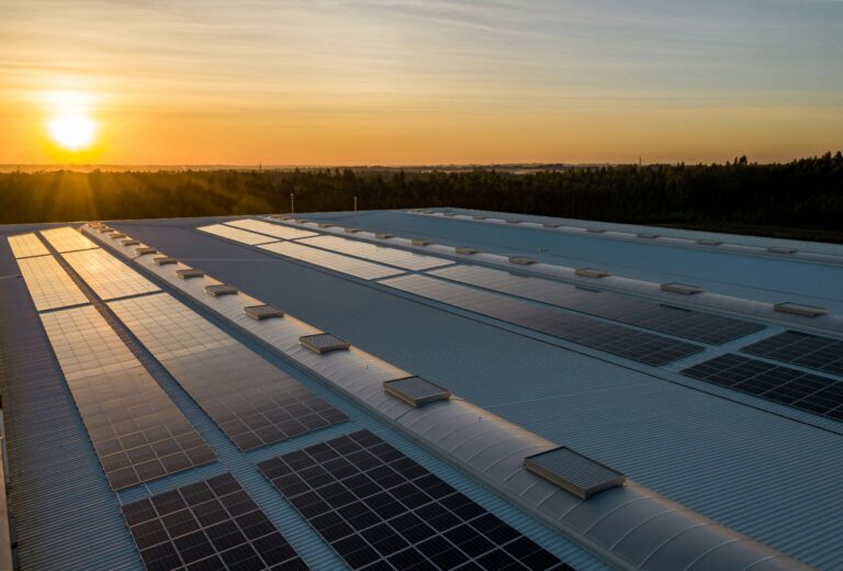 Solar panels on a building rooftop at sunset representing renewables